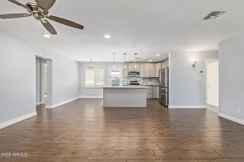 a view of kitchen with kitchen island white cabinets and stainless steel appliances