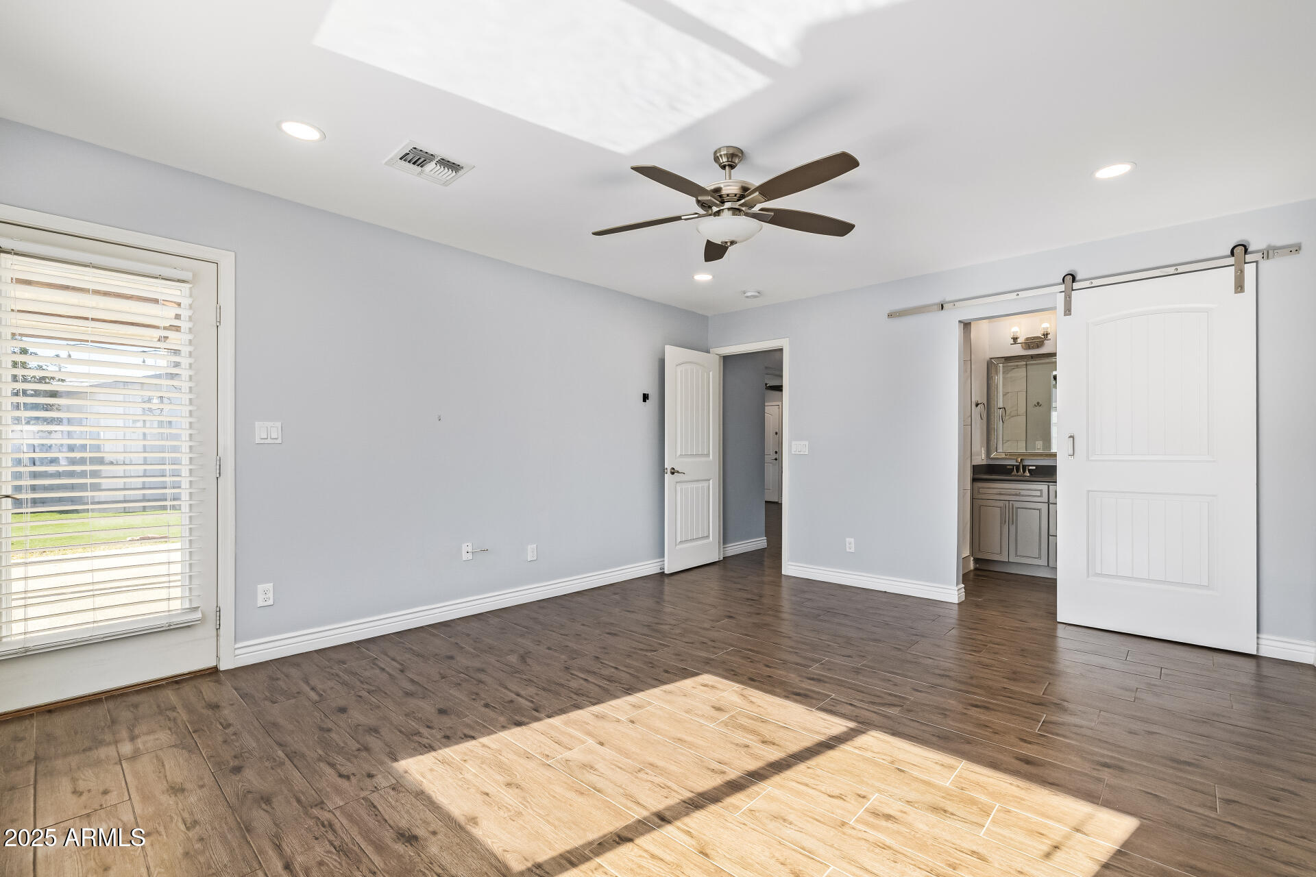2439 East Minnezona Avenue Phoenix, AZ 85016 - Photo 10 of 25 a view of an empty room with wooden floor and a window