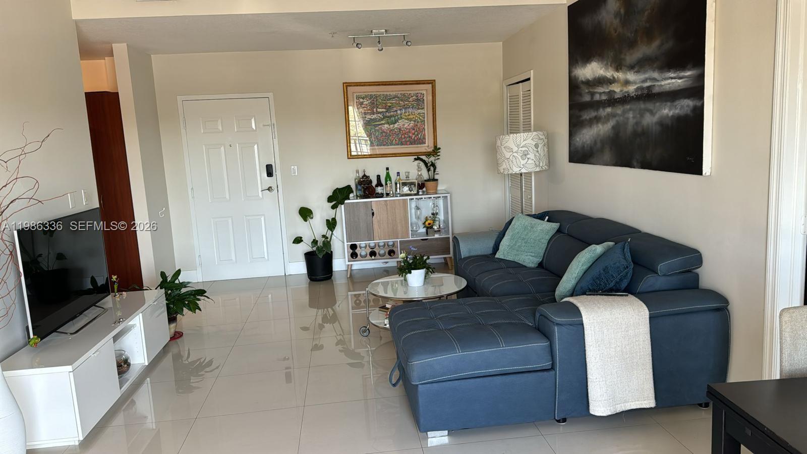 5271 Southwest 8th Street, Unit 405 Miami, FL 33134 - Photo 2 of 8 a living room with furniture and a flat screen tv