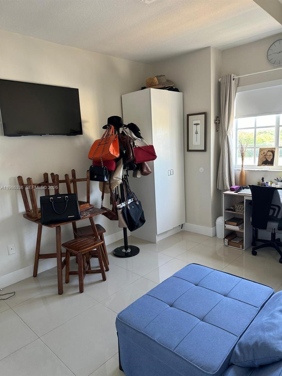 5271 Southwest 8th Street, Unit 405 Miami, FL 33134 - Photo 4 of 8 a living room with furniture and a flat screen tv