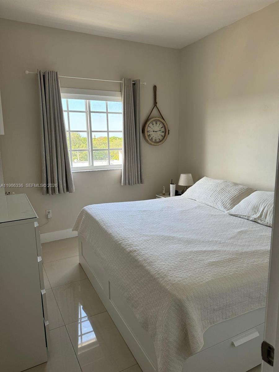 5271 Southwest 8th Street, Unit 405 Miami, FL 33134 - Photo 7 of 8 a bedroom with a bed and a window