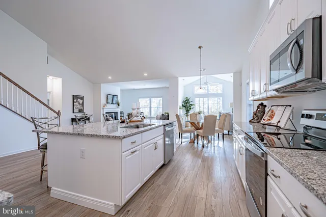 a kitchen with granite countertop a sink stove and cabinets