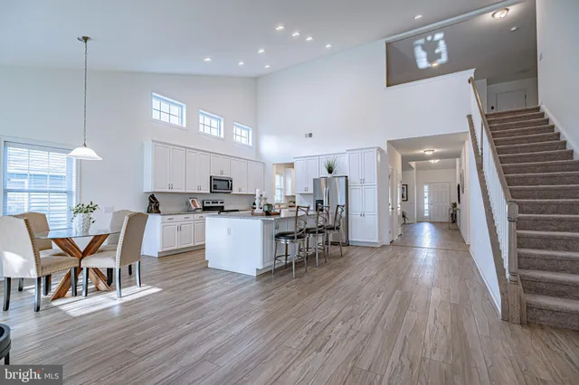a view of a kitchen with dining room wooden floor and windows