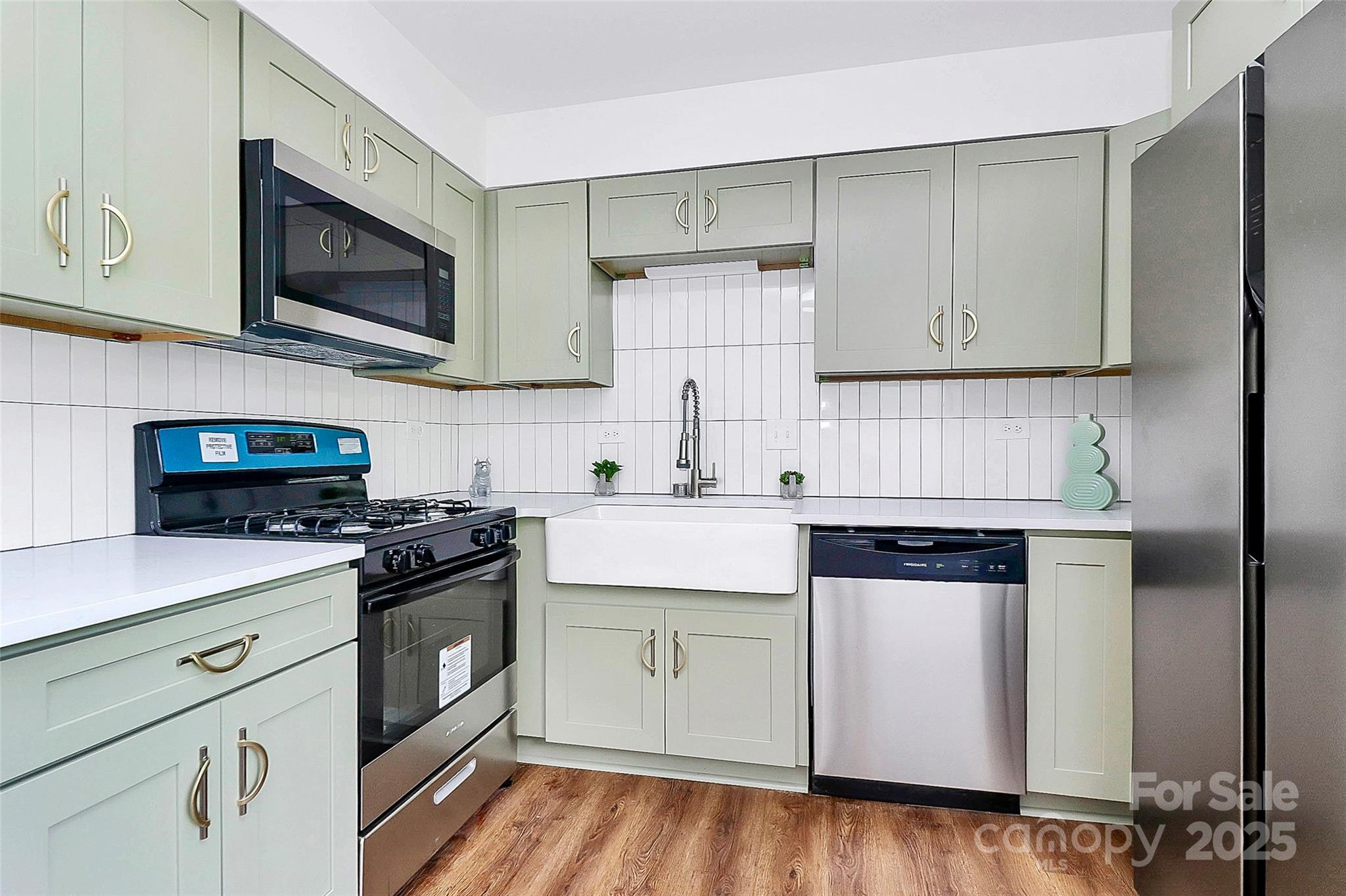1300 Queens Road, Unit 405 Charlotte, NC 28207 - Photo 11 of 36 a kitchen with stainless steel appliances granite countertop a stove a sink and a microwave