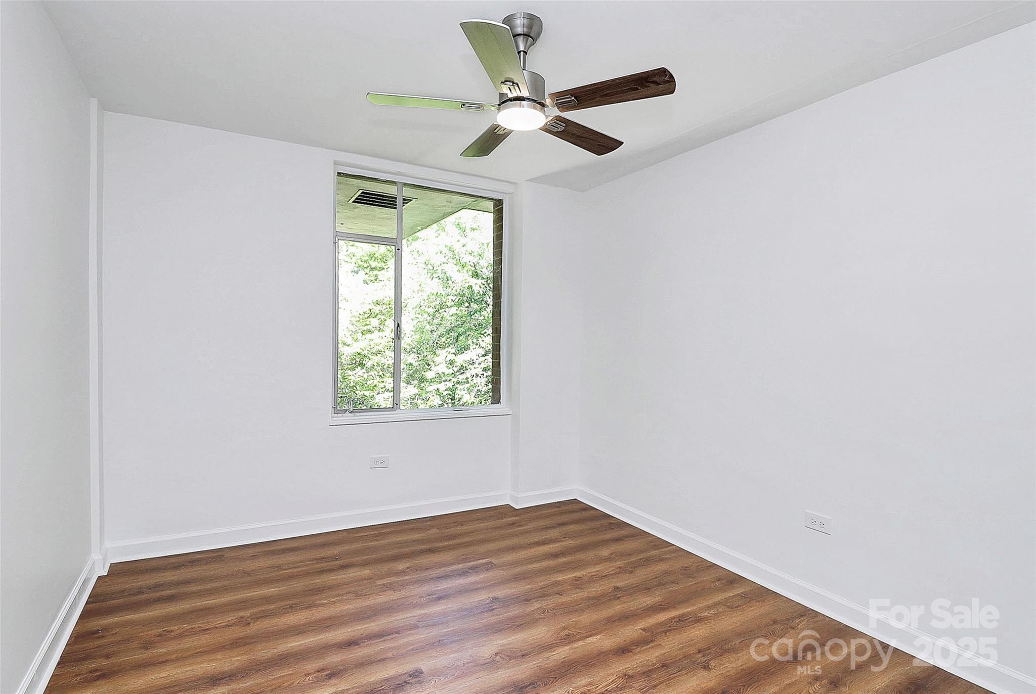 1300 Queens Road, Unit 405 Charlotte, NC 28207 - Photo 15 of 36 an empty room with wooden floor and windows