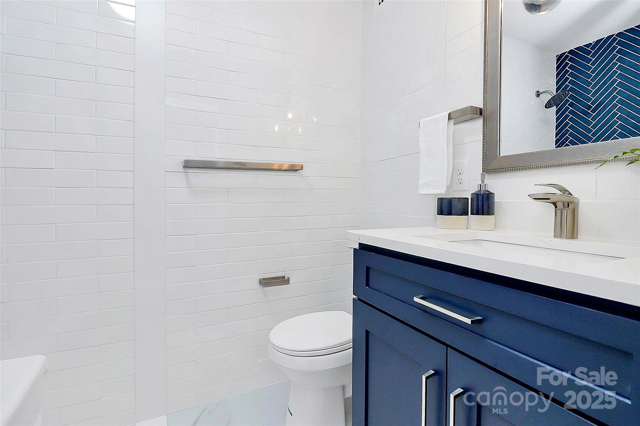 1300 Queens Road, Unit 405 Charlotte, NC 28207 - Photo 22 of 36 a bathroom with a sink a toilet and mirror