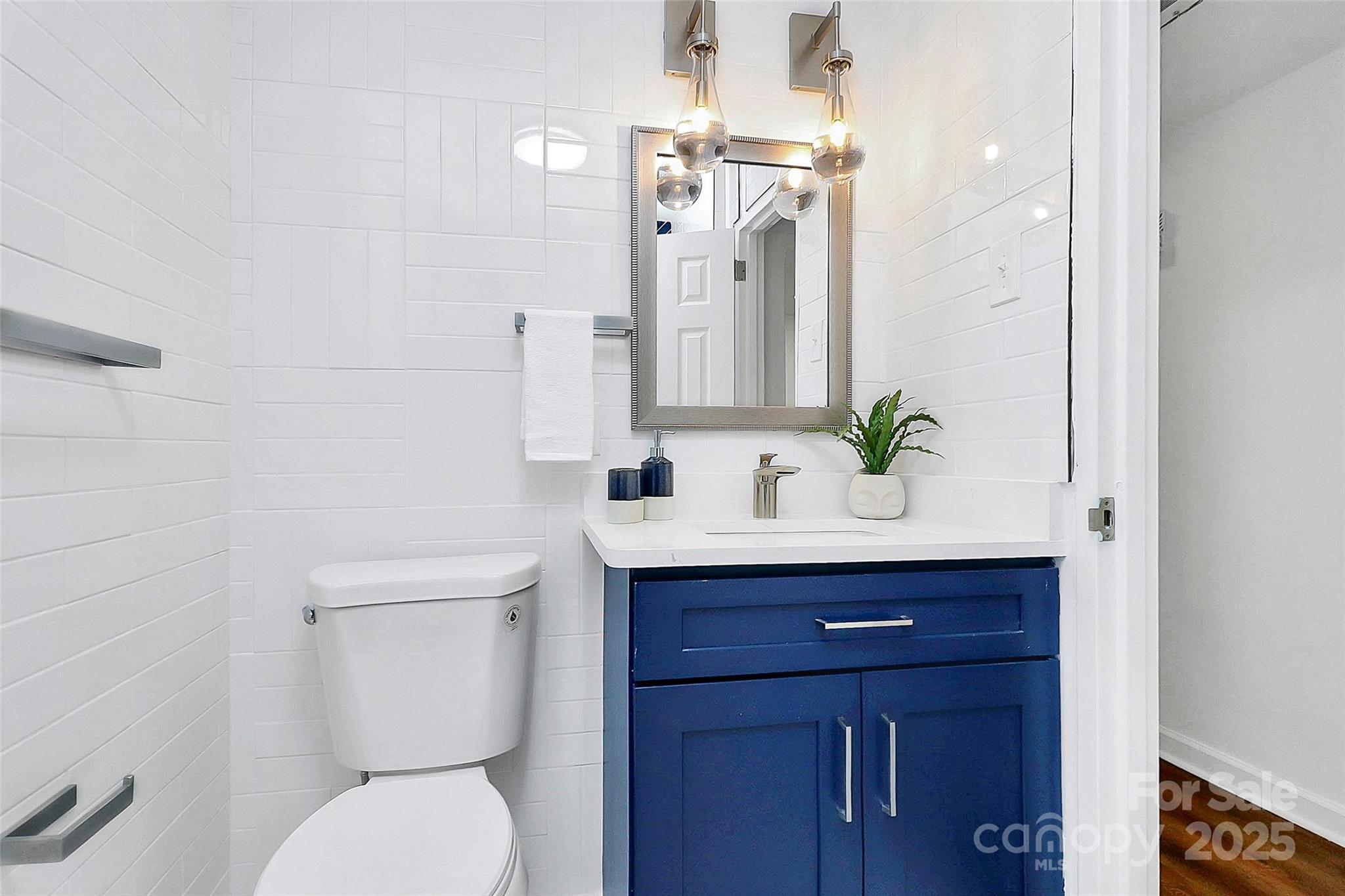 1300 Queens Road, Unit 405 Charlotte, NC 28207 - Photo 23 of 36 a bathroom with a toilet sink and mirror