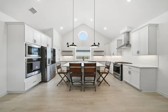 a large kitchen with a table and chairs