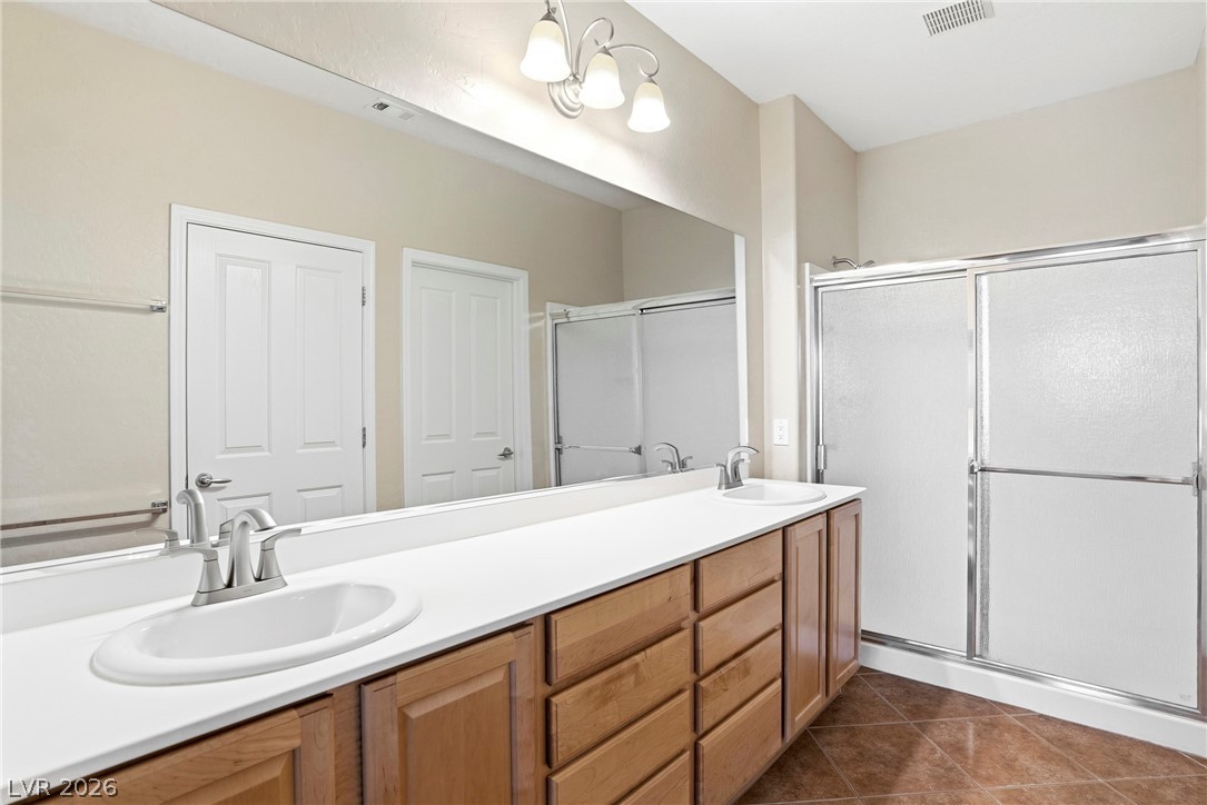 2541 Darda Street Henderson, NV 89044 - Photo 18 of 26 This spacious bathroom offers a double vanity with ample counter space and a convenient shower.