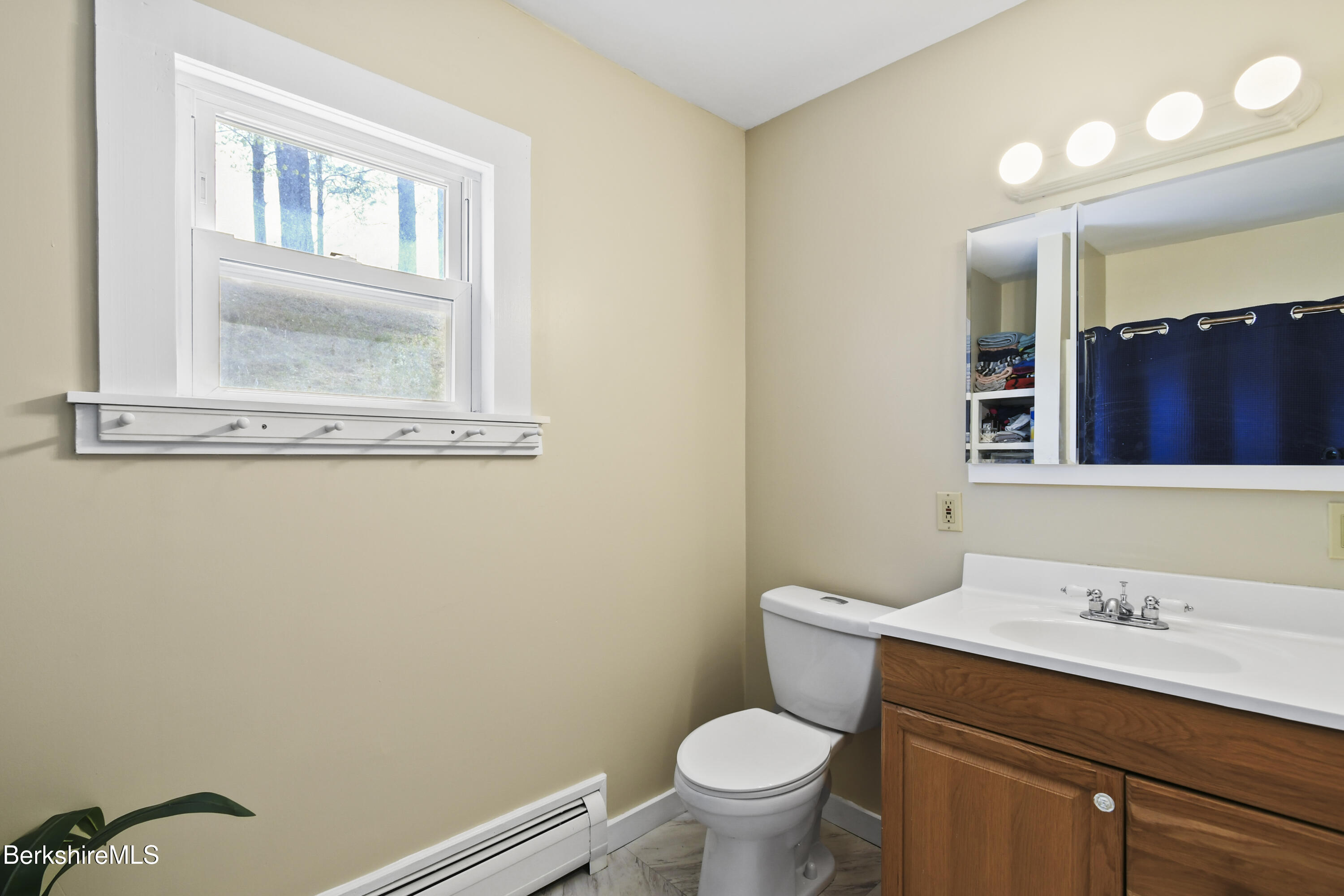 28 Upton Street Adams, MA 01220 - Photo 13 of 29 a bathroom with a toilet a sink a mirror and a window