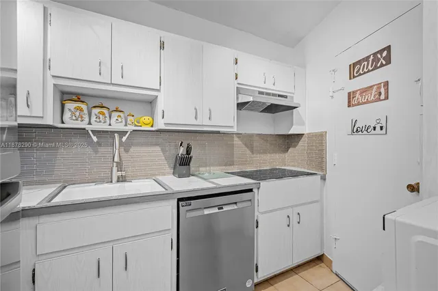 a kitchen with stainless steel appliances granite countertop a sink and dishwasher with white cabinets