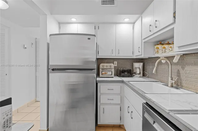a kitchen with a refrigerator sink and cabinets