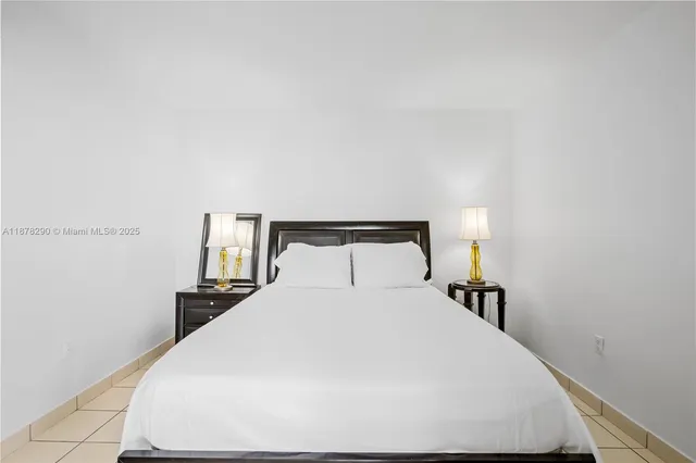 a large bed sitting in a bedroom and a lamp