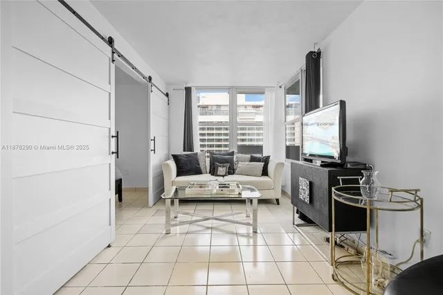 a living room with furniture a flat screen tv and a window