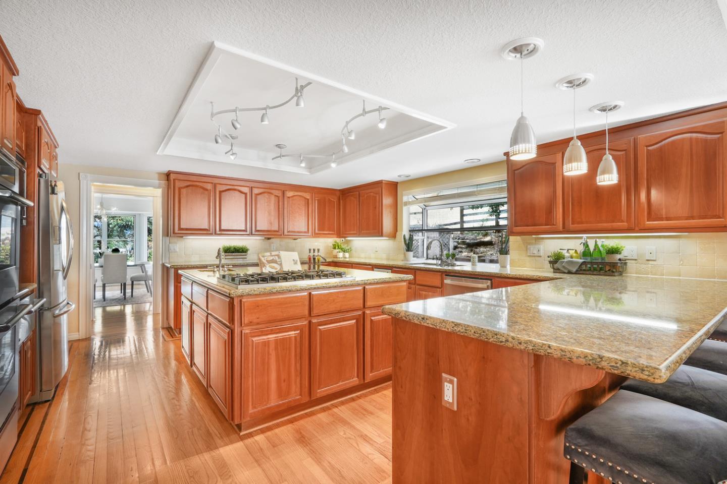 1245 Day Road Gilroy, CA 95020 - Photo 9 of 55 a kitchen with stainless steel appliances granite countertop a refrigerator a sink dishwasher a stove and white countertops with wooden floor