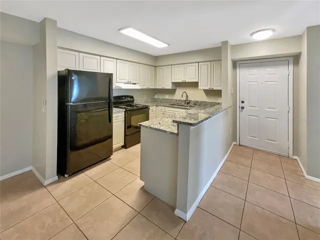 a kitchen with stainless steel appliances granite countertop a refrigerator and a stove top oven