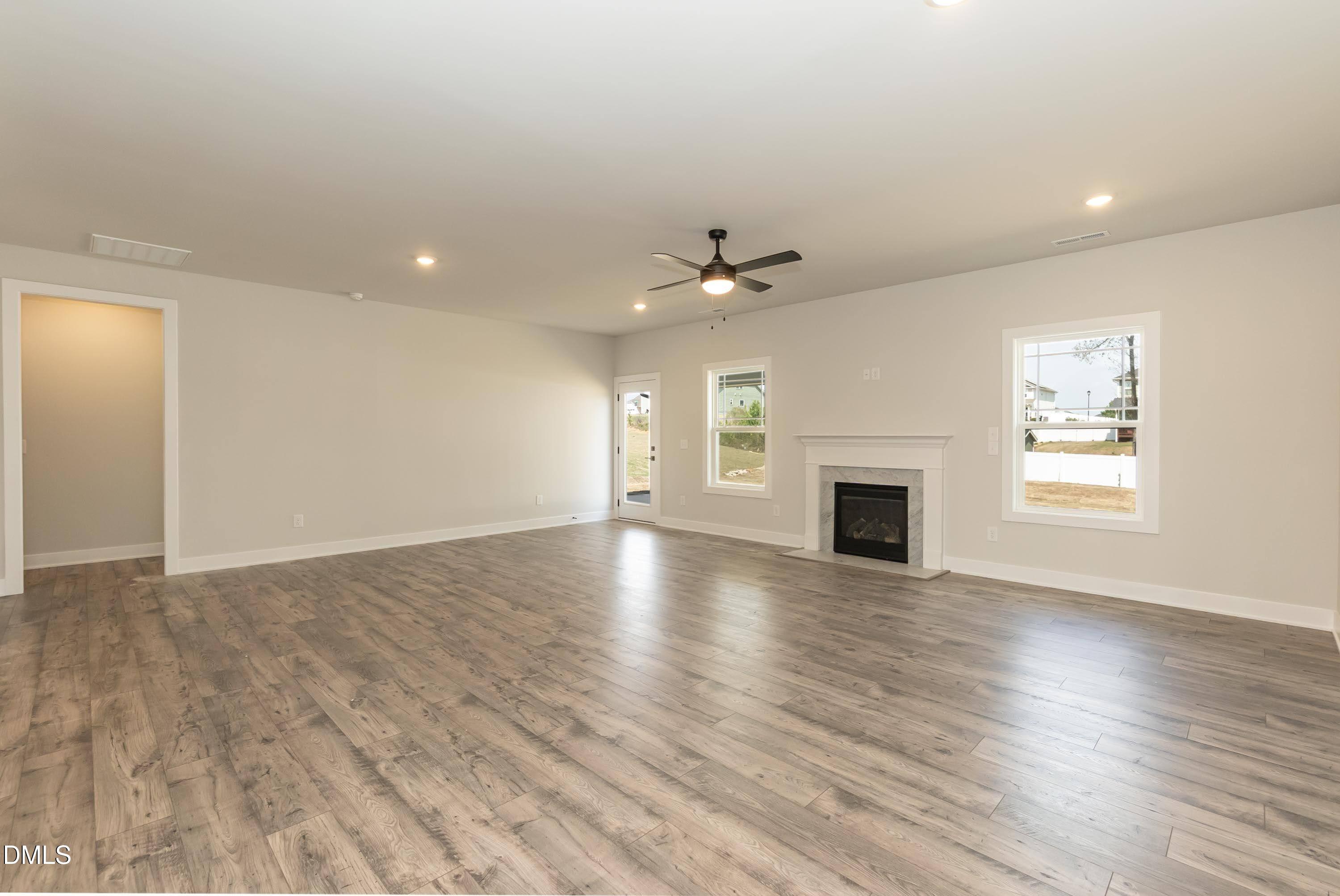 104 Galway Road Lillington, NC 27546 - Photo 17 of 40 an empty room with wooden floor fireplace and windows
