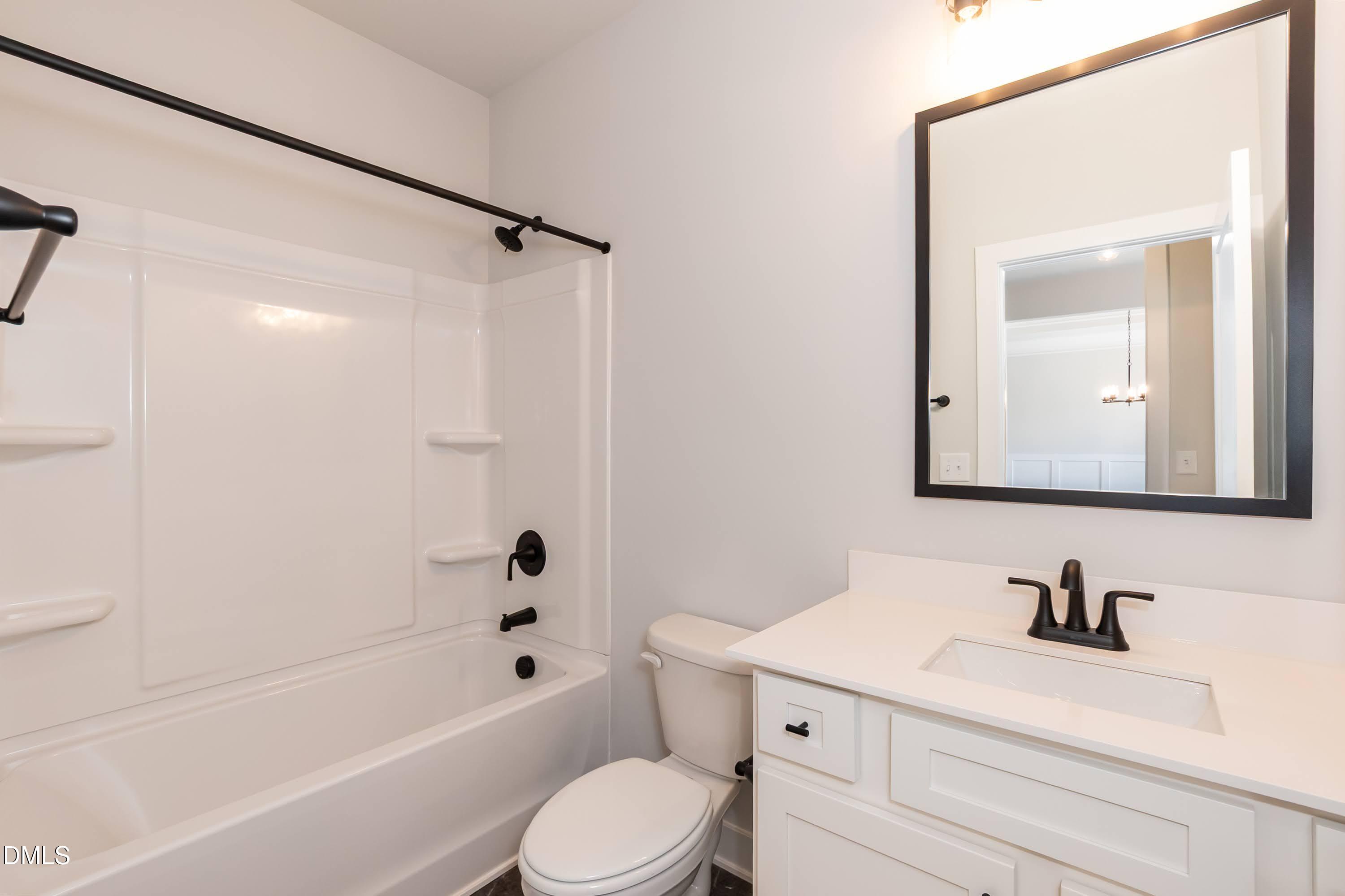 104 Galway Road Lillington, NC 27546 - Photo 26 of 40 a bathroom with a bathtub shower sink vanity mirror and toilet
