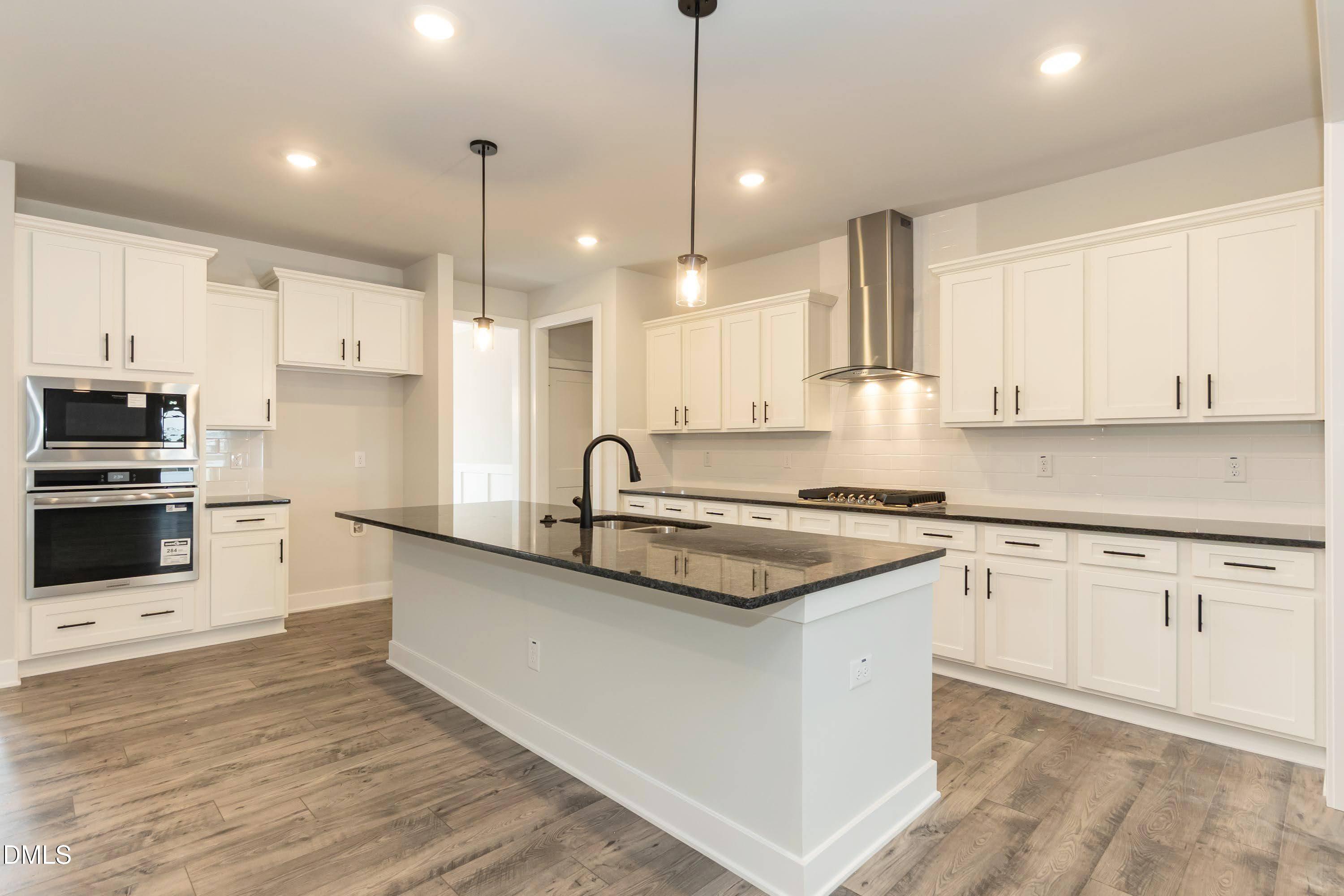104 Galway Road Lillington, NC 27546 - Photo 2 of 40 a kitchen with stainless steel appliances granite countertop a sink a stove a refrigerator and white cabinets with wooden floor