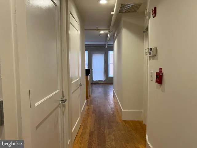 a view of a hallway with wooden floor and staircase