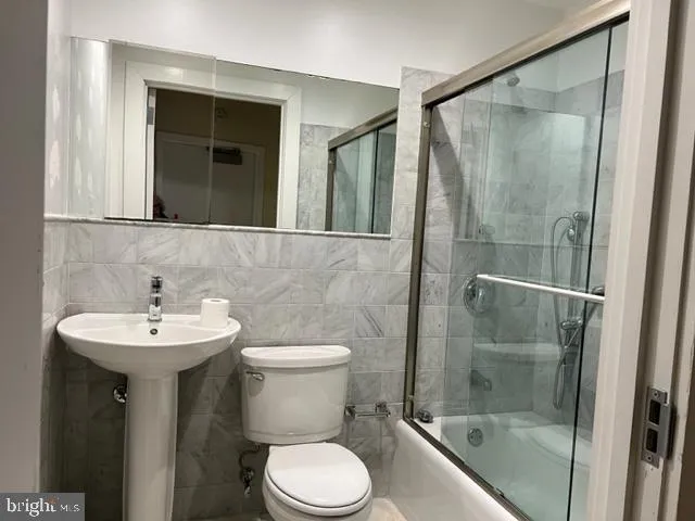a bathroom with a sink mirror toilet and shower