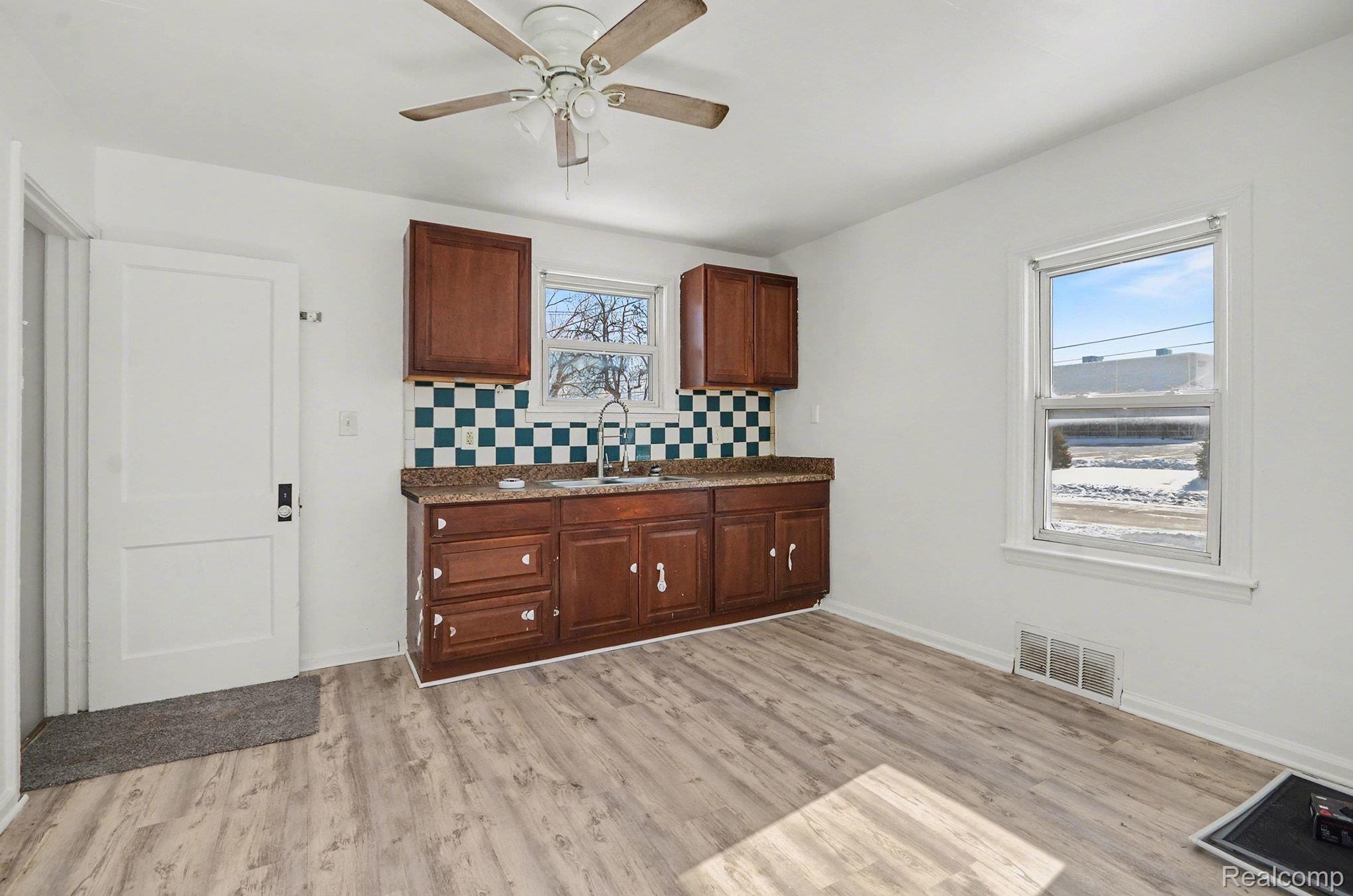 23346 Hoover Road Warren, MI 48089 - Photo 4 of 15 Kitchen with light wood-type flooring, backsplash, and a ceiling fan