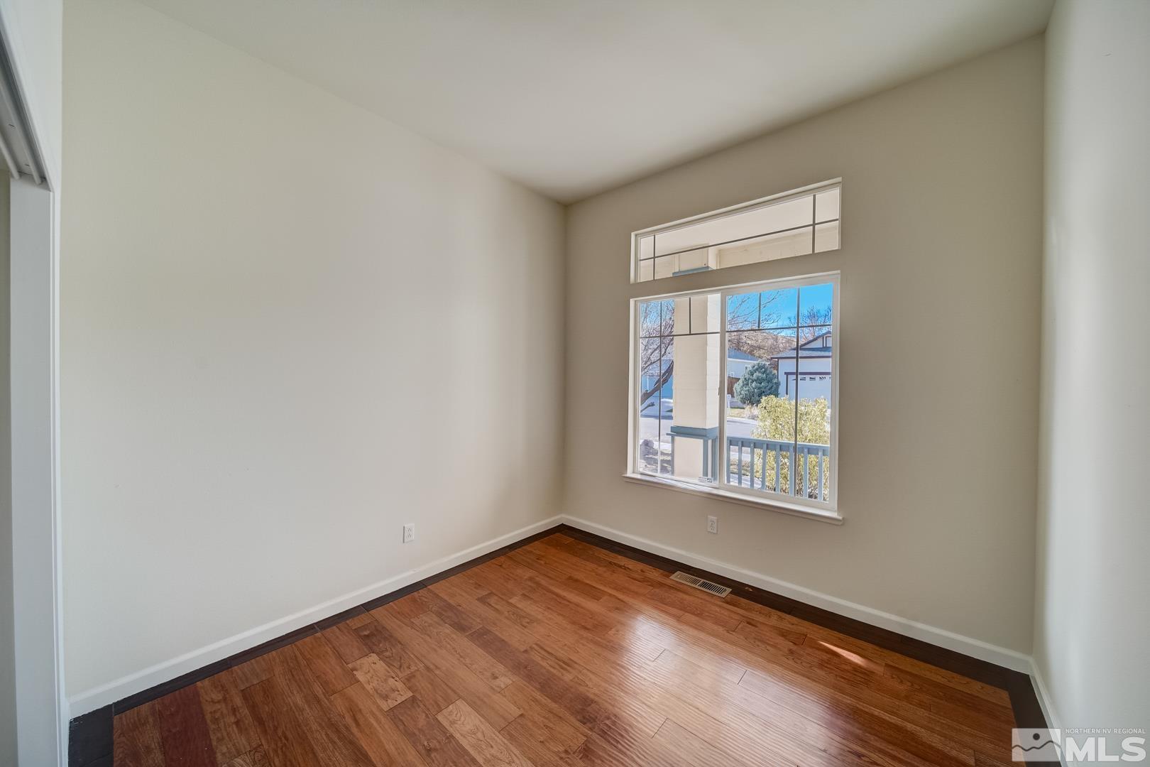 7560 Michaela Drive Reno, NV 89511 - Photo 17 of 32 an empty room with wooden floor and windows