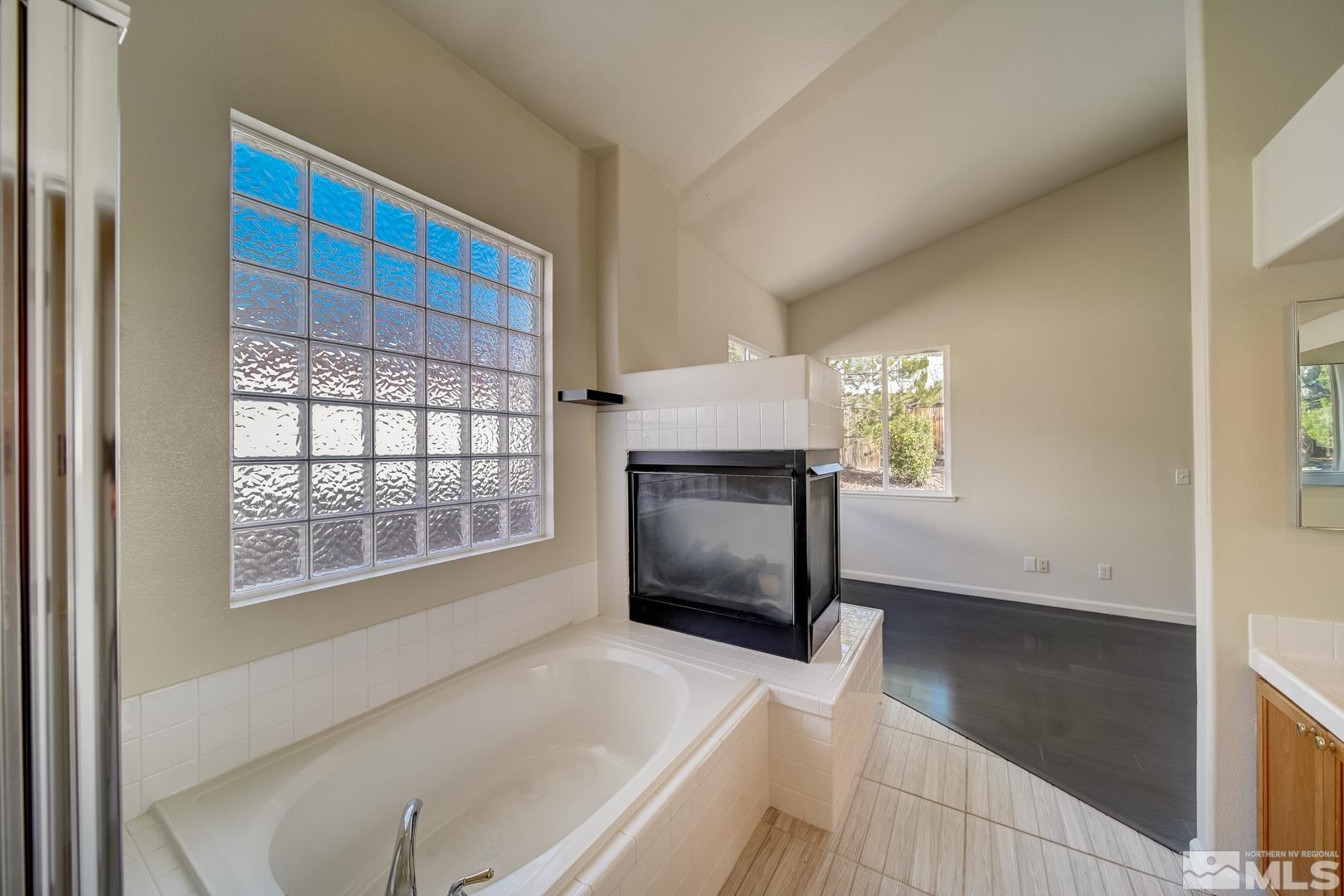 7560 Michaela Drive Reno, NV 89511 - Photo 29 of 32 a living room with a fireplace furniture a rug and a window