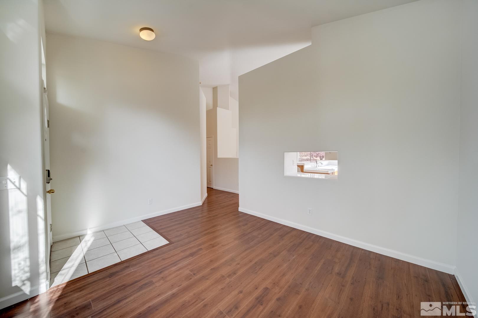 7560 Michaela Drive Reno, NV 89511 - Photo 5 of 32 an empty room with wooden floor and windows