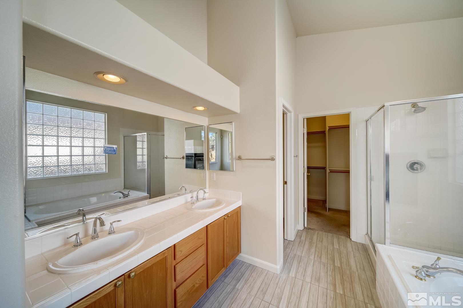 7560 Michaela Drive Reno, NV 89511 - Photo 8 of 32 a bathroom with a double vanity sink a mirror and a shower