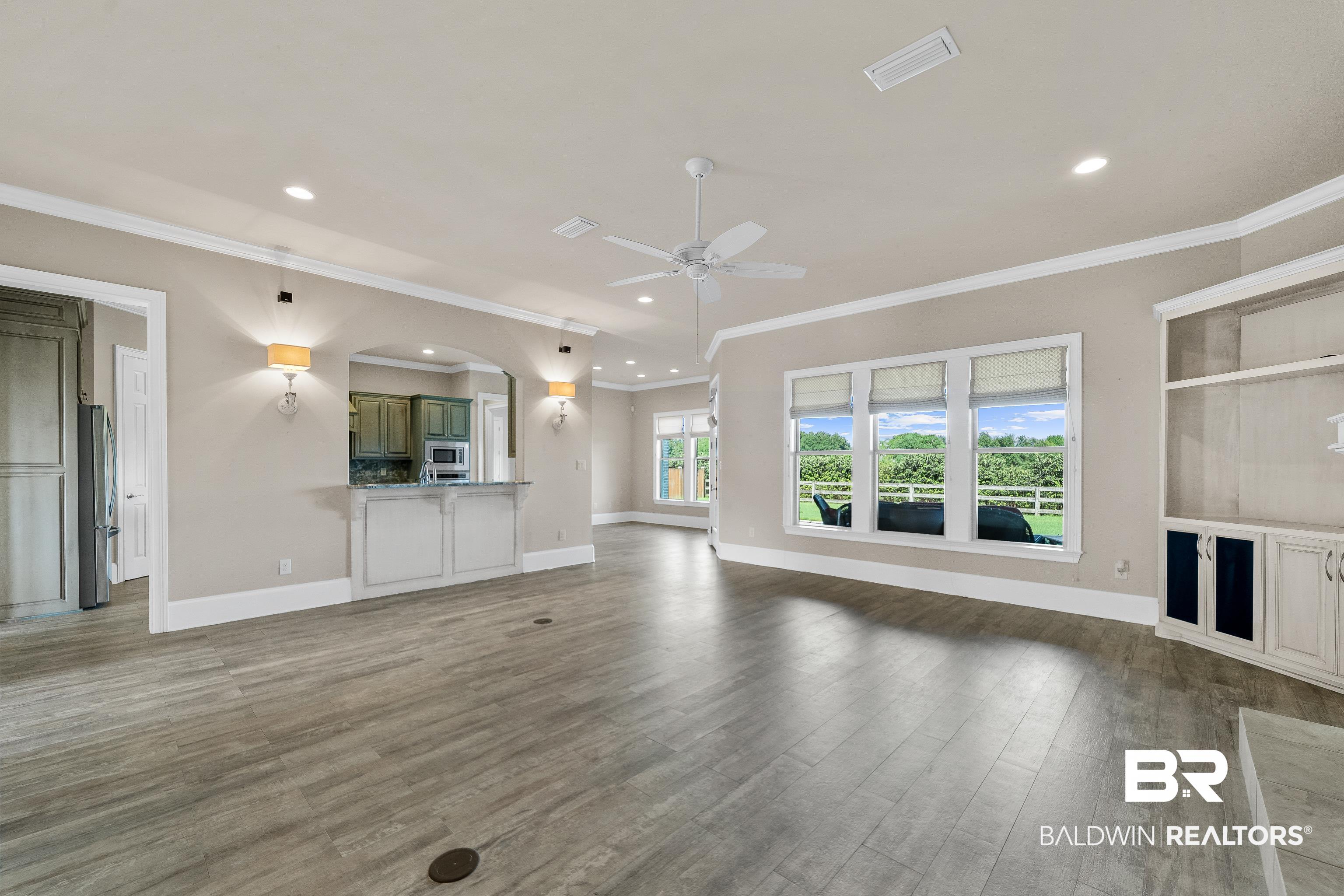 17663 Burwick Loop Fairhope, AL 36532 - Photo 12 of 41 Unfurnished living room with wood-type flooring, ornamental molding, and ceiling fan