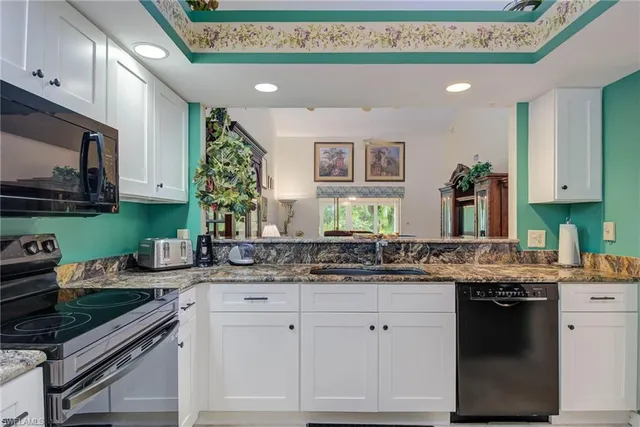 a kitchen with granite countertop a sink stove and cabinets