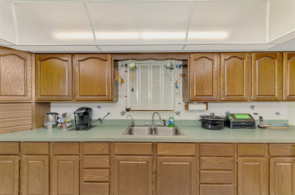 1137 Ponderosa Road Venice, FL 34293 - Photo 18 of 48 a kitchen with sink a window and cabinets