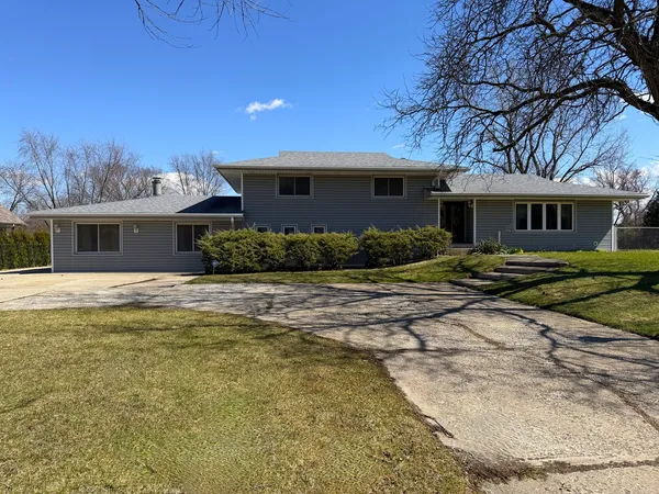 a front view of house with yard and trees around