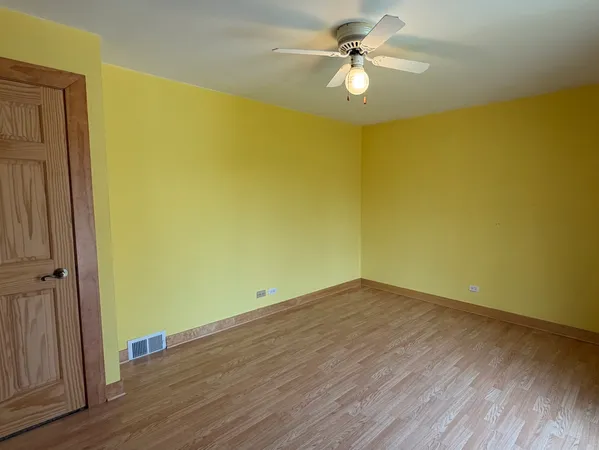a view of a big room with wooden floor and a ceiling fan