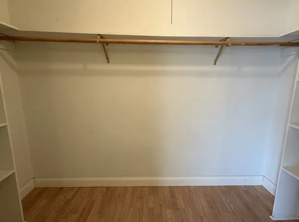 a view of walk in closet with empty racks