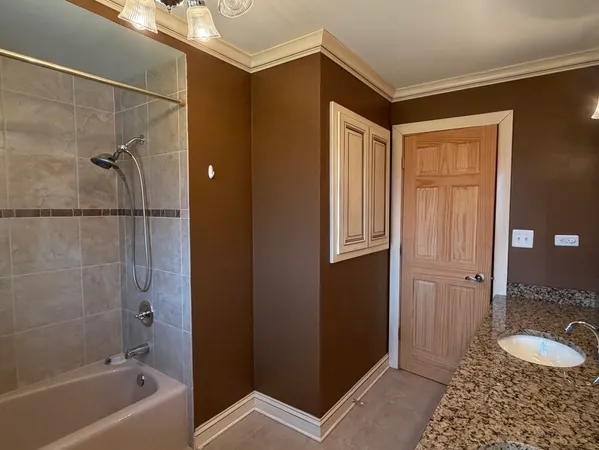 a bathroom with a granite countertop sink and shower