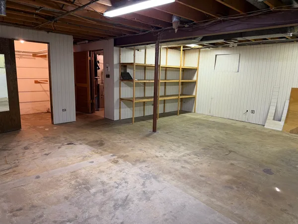 a view of an empty room with furniture and a window