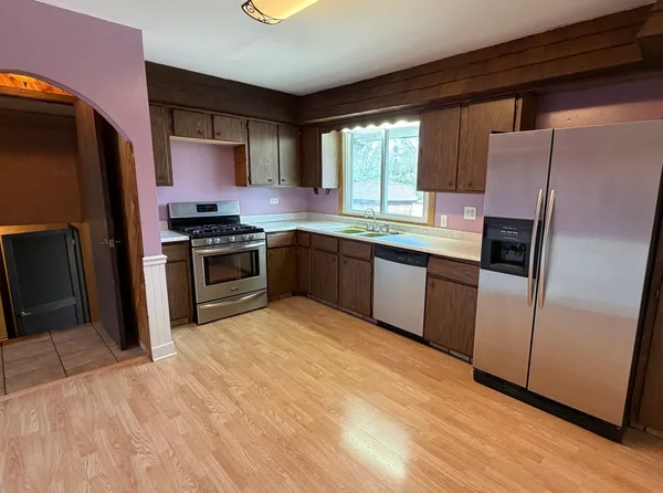 a kitchen with stainless steel appliances granite countertop a stove a refrigerator and a sink