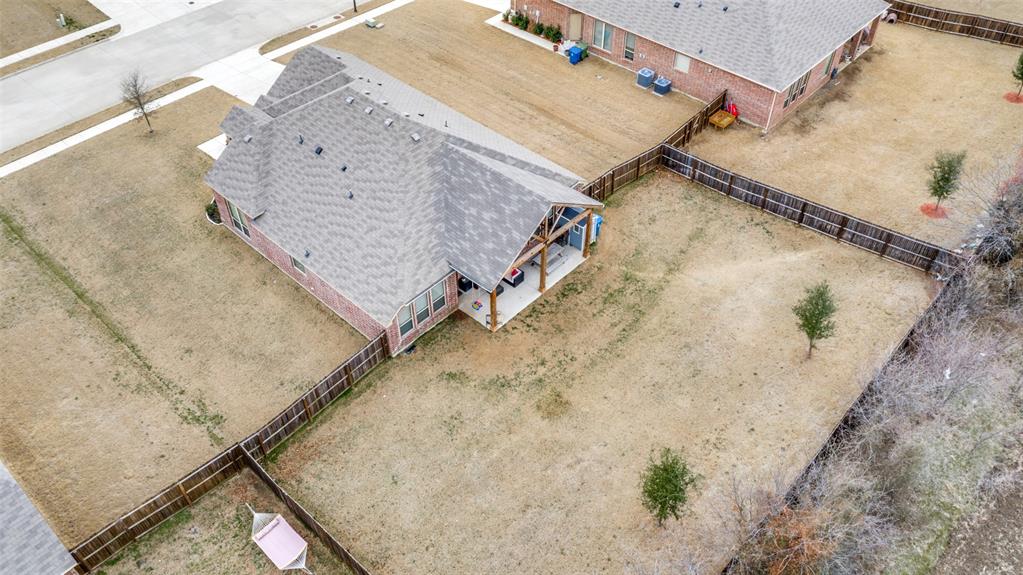 an aerial view of a house with a yard and wooden deck