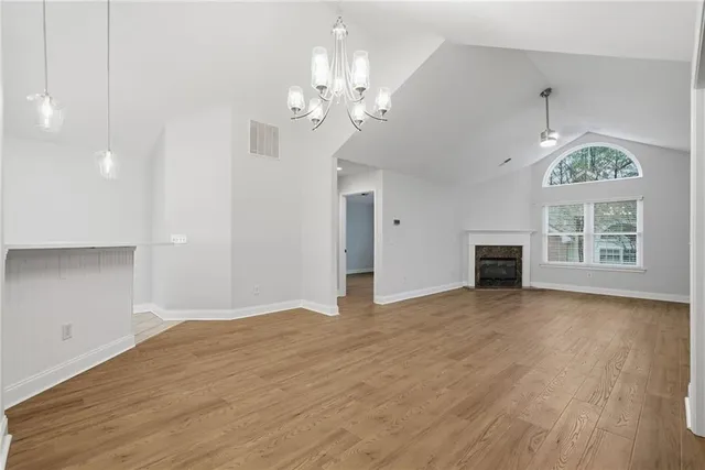 a view of an empty room with a window and fireplace