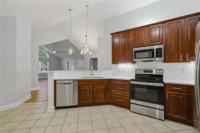 a kitchen with stainless steel appliances granite countertop a stove microwave and sink