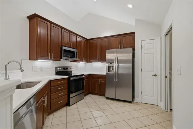 a kitchen with stainless steel appliances granite countertop a refrigerator and a sink