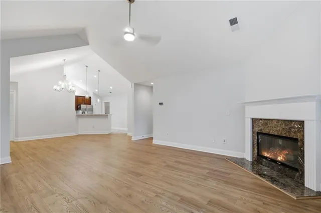 an empty room with wooden floor fireplace and windows