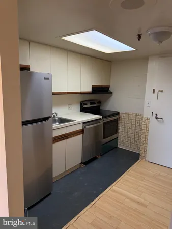 a kitchen with stainless steel appliances granite countertop a refrigerator a sink and a stove