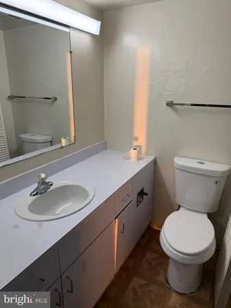 a bathroom with a sink a toilet and a mirror
