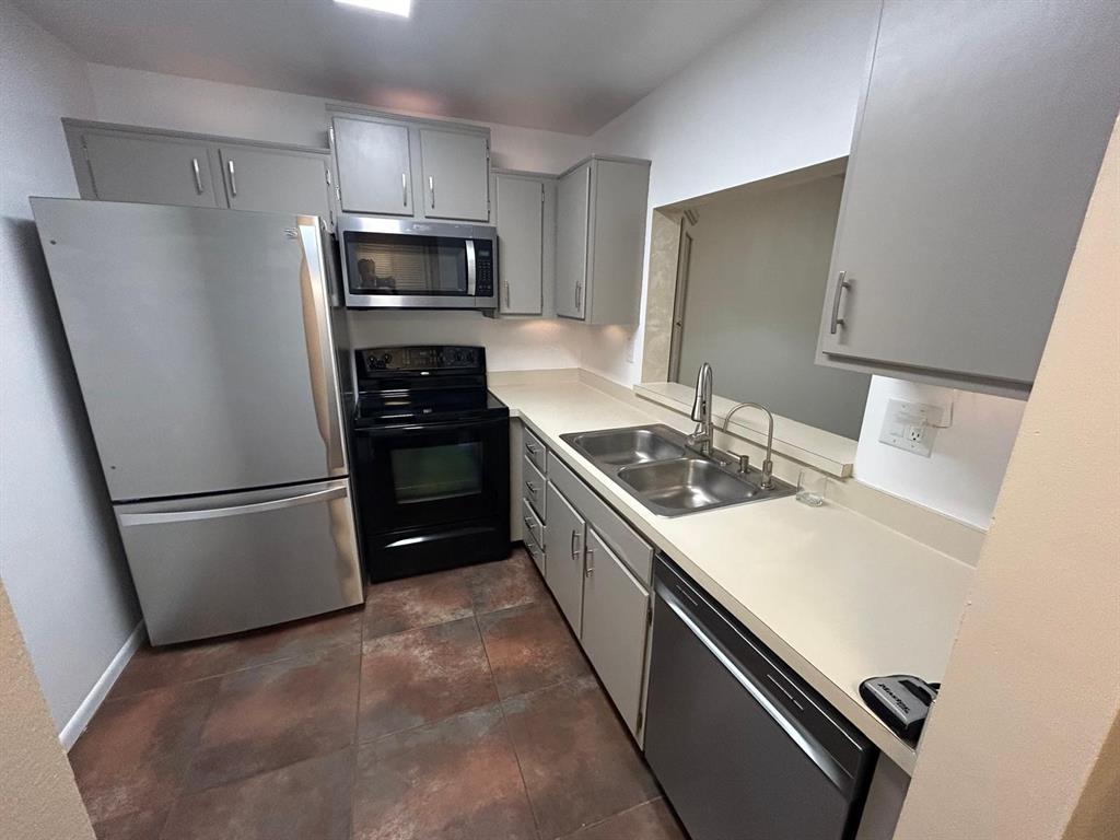 4147 Northwest 90th Avenue, Unit 206 Coral Springs, FL 33065 - Photo 15 of 37 a kitchen with a sink a refrigerator and a stove top oven