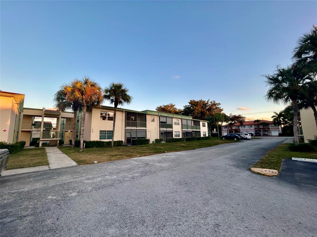 4147 Northwest 90th Avenue, Unit 206 Coral Springs, FL 33065 - Photo 2 of 37 a front view of a house with a yard and street view