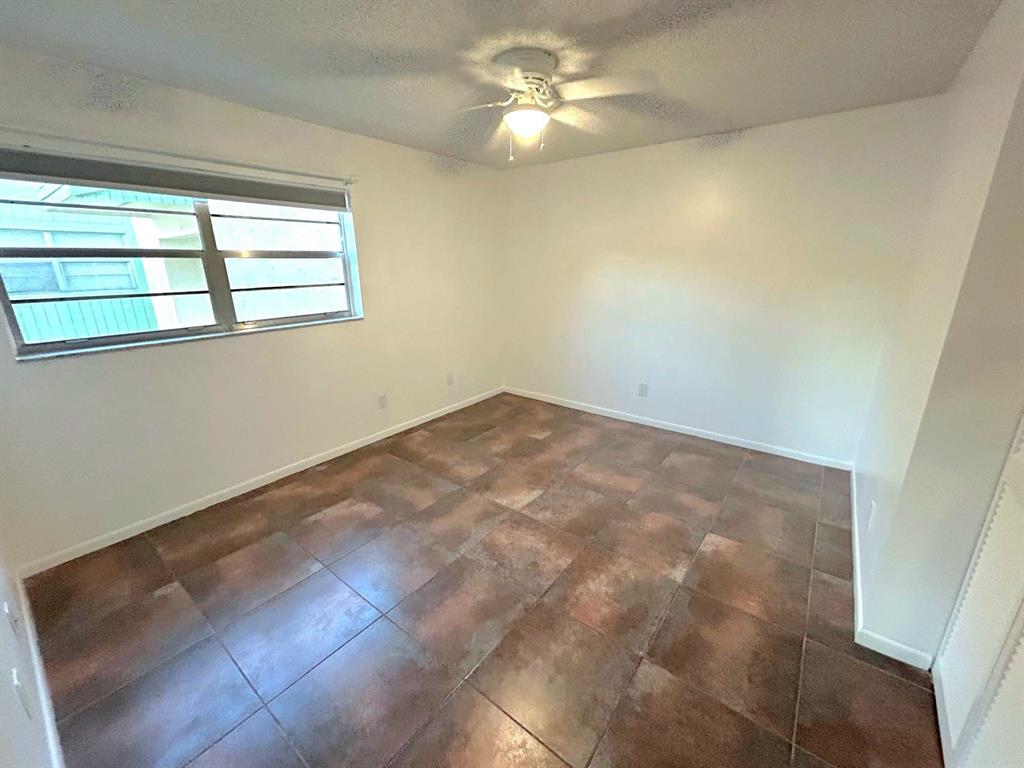 4147 Northwest 90th Avenue, Unit 206 Coral Springs, FL 33065 - Photo 24 of 37 en empty room with windows and ceiling fan