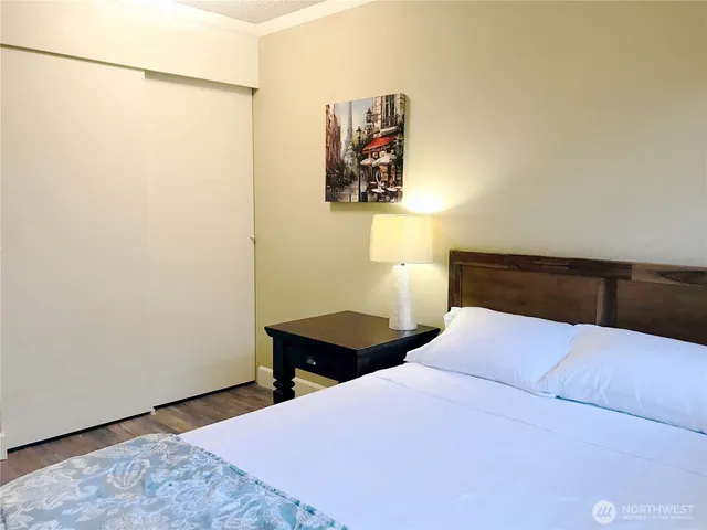 a bedroom with a bed and a lamp on the dresser